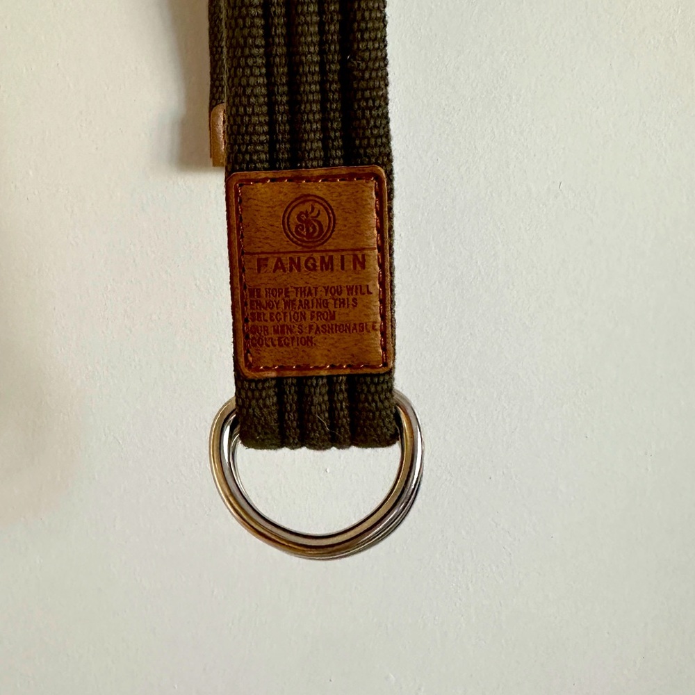 Green canvas double ring belt on green.